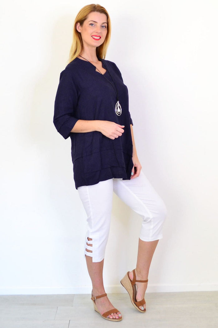 Hourglass denim linen blend tunic top displayed on a hanger, featuring a relaxed fit and casual style in light blue fabric.
