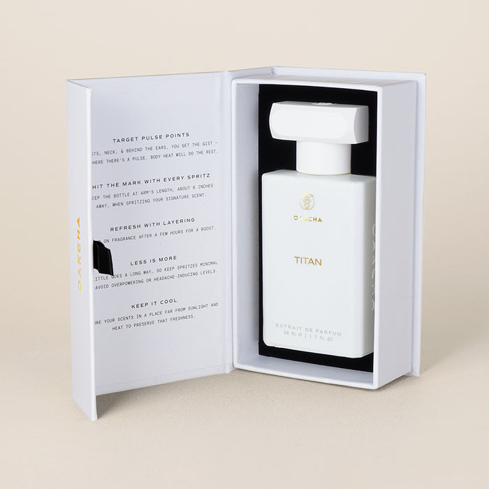 Front view of Titan perfume bottle in open white presentation box with black foam insert and beige background