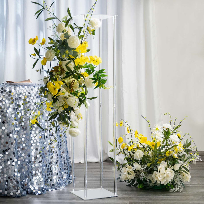 Clear acrylic floral display stand with yellow and white flowers.