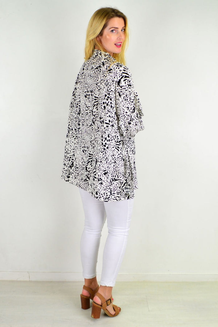 Black giraffe print relaxed fit tunic blouse by Hourglass, featuring loose style and black-and-white animal print fabric.