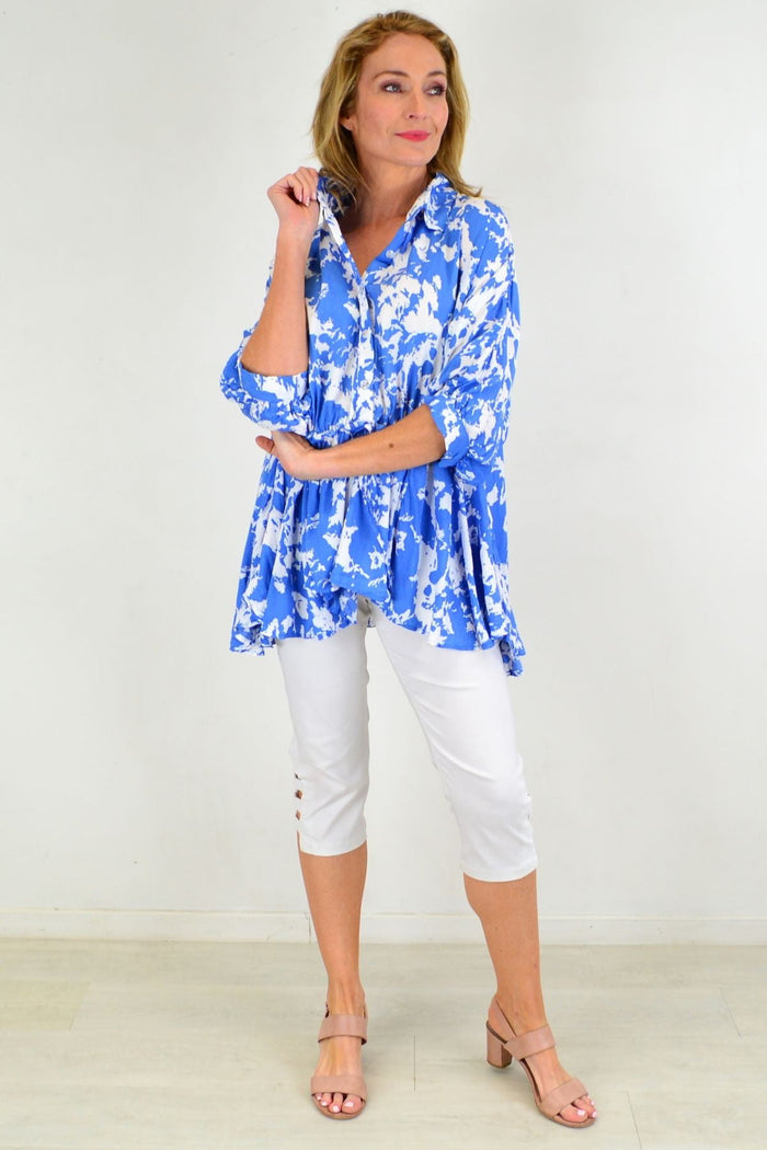 Blue Hourglass Follow Me relaxed fit tunic blouse with long sleeves and a V-neck, displayed on a hanger against a neutral background.