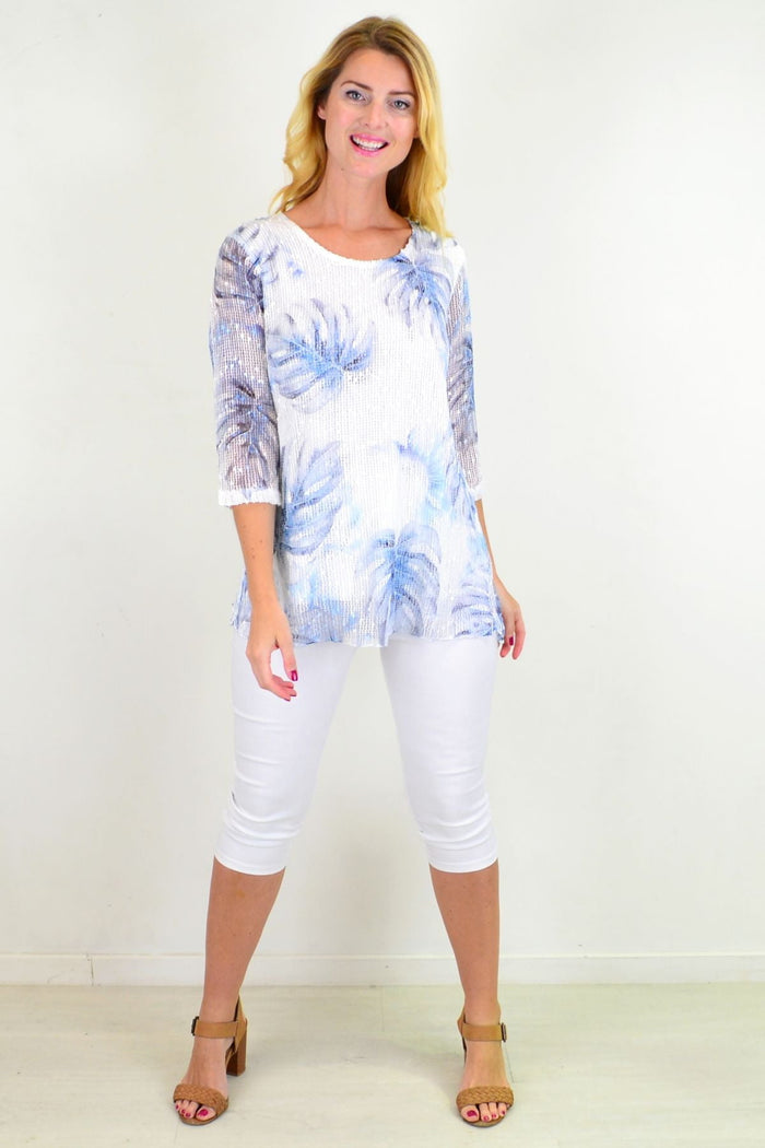 Blue tropical sequin tunic top by Ruby Rain featuring vibrant sequins and relaxed fit, displayed on a hanger.