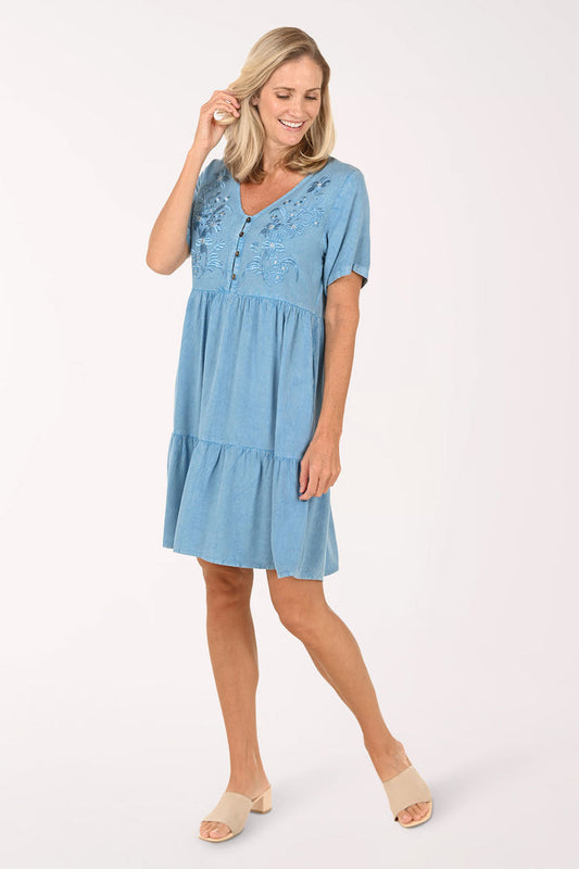 Woman wearing a blue dress with lace details on a white background