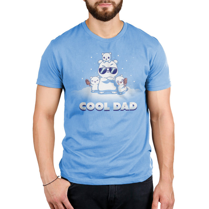 Premium Cotton T-shirt_TeeTurtle light blue Cool Dad (Polar Bear) apparel featuring a dad polar bear with sunglasses and his arms crossed, two of his cubs holding frozen desserts, one cub perched on top of his head with snow falling around them, and the caption, "Cool Dad".