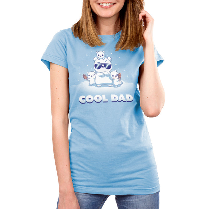 Premium Cotton T-shirt_TeeTurtle light blue Cool Dad (Polar Bear) apparel featuring a dad polar bear with sunglasses and his arms crossed, two of his cubs holding frozen desserts, one cub perched on top of his head with snow falling around them, and the caption, "Cool Dad".