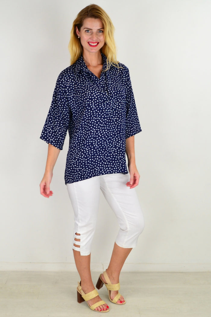 Stylius Dot in a Dot tunic top with a relaxed fit, featuring a playful dotted pattern and long sleeves, displayed on a hanger.