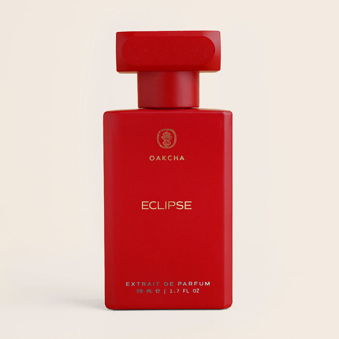 Front view of Eclipse perfume bottle showing matte red rectangular bottle and matching cap on beige background