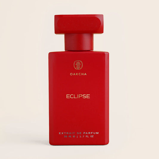 Front view of Eclipse perfume bottle showing matte red rectangular bottle and matching cap on beige background