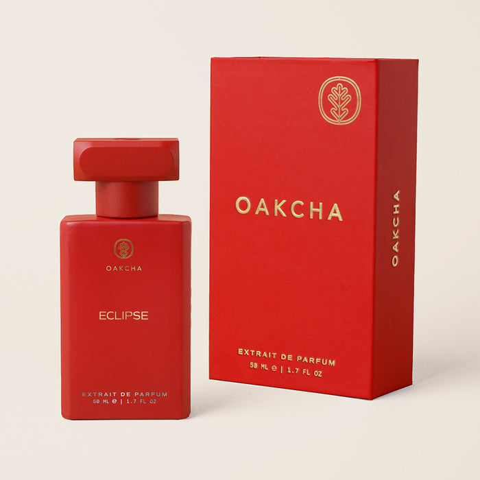 Front view of Eclipse perfume bottle with matching red box showcasing matte red finish and gold Oakcha logo on cream background