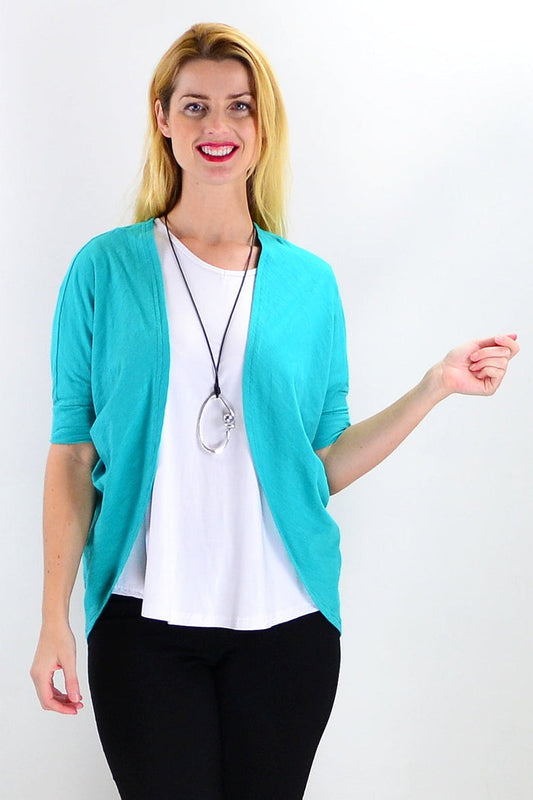 Freez Emerald Mini Shrug Cardigan worn as a tunic, featuring a vibrant emerald color and lightweight knit fabric.