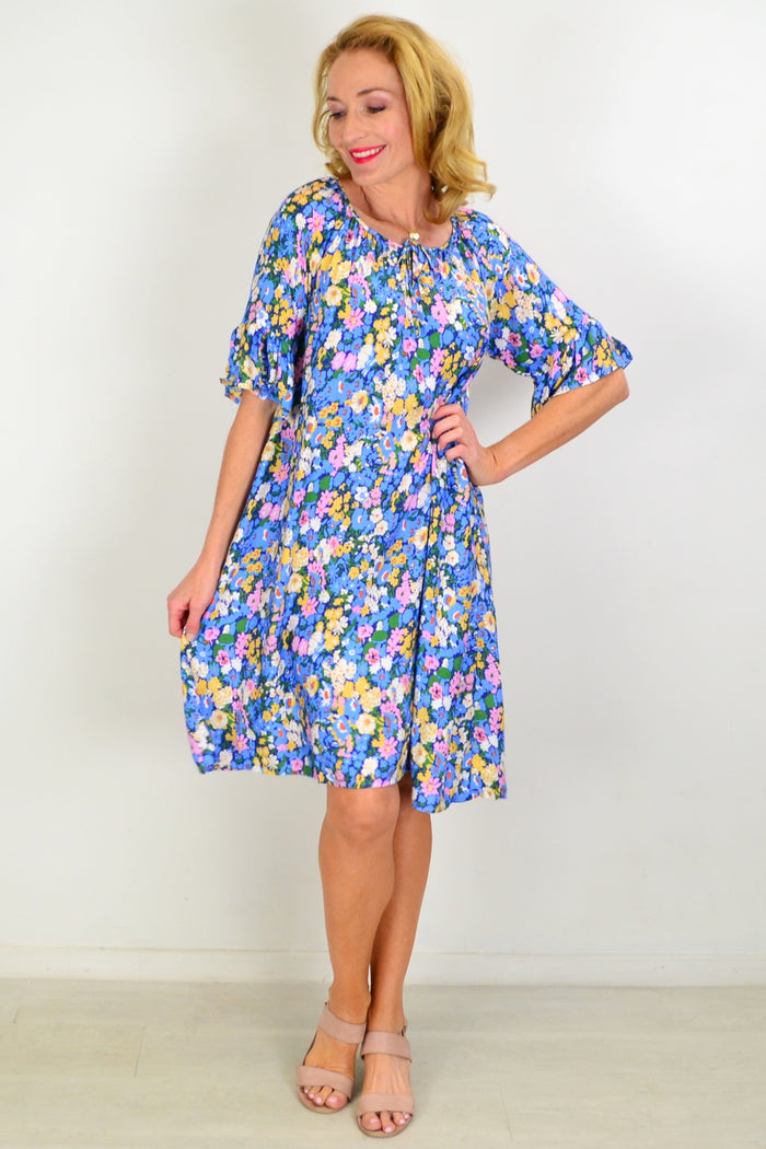 Hourglass Fairy Garden shift tunic dress hanging on a display, featuring floral patterns and lightweight fabric.