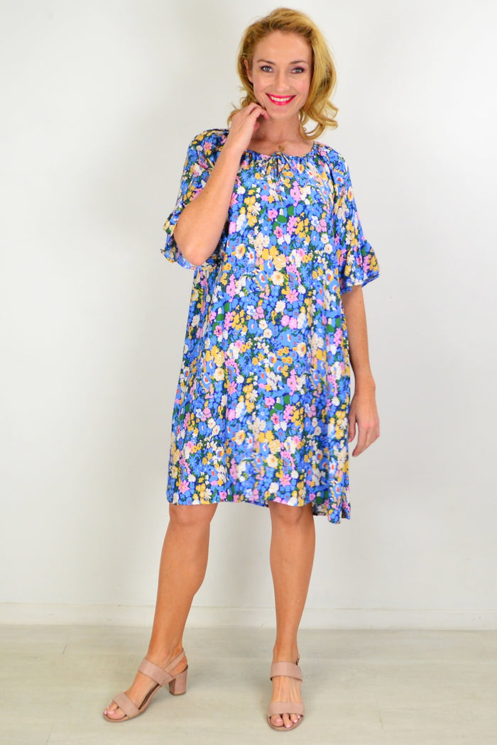 Hourglass Fairy Garden Shift Tunic Dress displayed on a hanger, featuring a floral print, lightweight fabric, and relaxed fit.