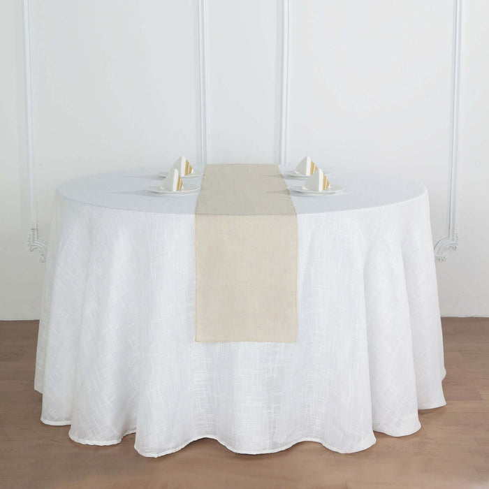 Round dining table with white tablecloth and beige runner