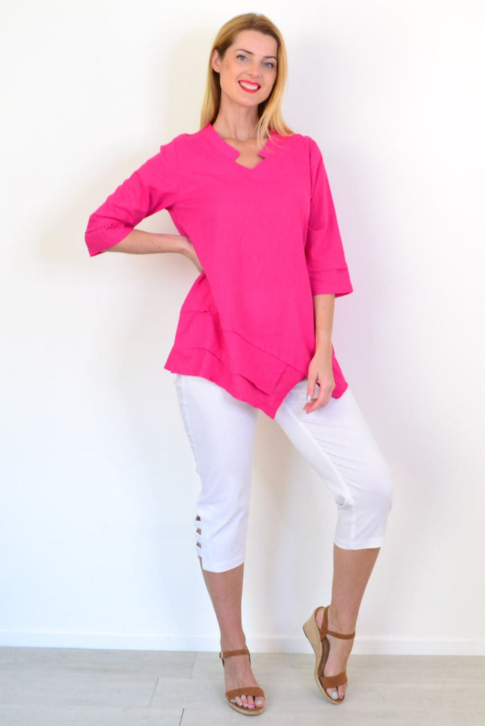 Hot pink linen blend tunic top by Hourglass with long sleeves and a relaxed fit, displayed on a hanger against a neutral background.