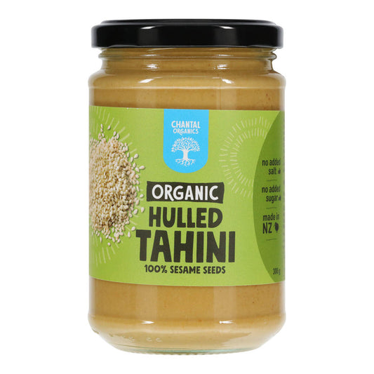 Jar of organic hulled tahini with a green label on a white background