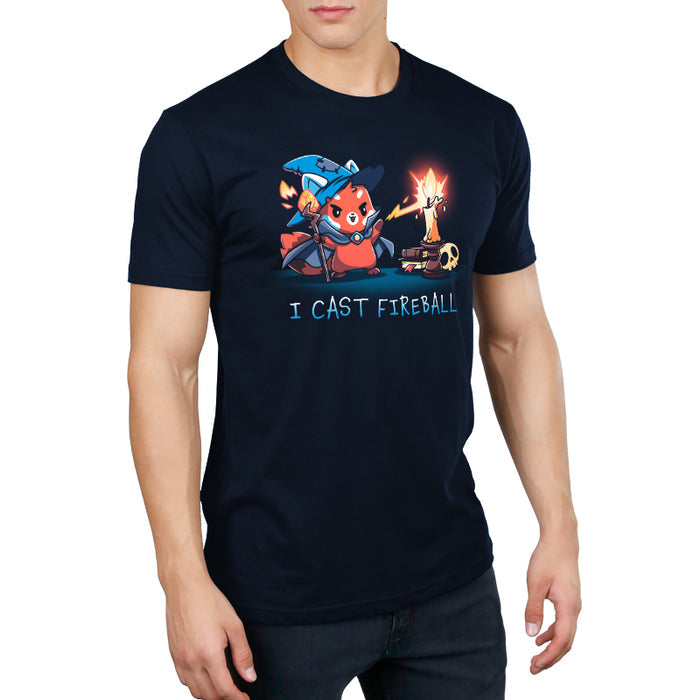 Premium Cotton T-shirt_TeeTurtle I Cast Fireball navy blue t-shirt featuring a fox in a tabletop game wizard outfit with a staff who casts a fireball spell towards a candle, with the text "I CAST FIREBALL" below. A stack of books and a skull are in the background.