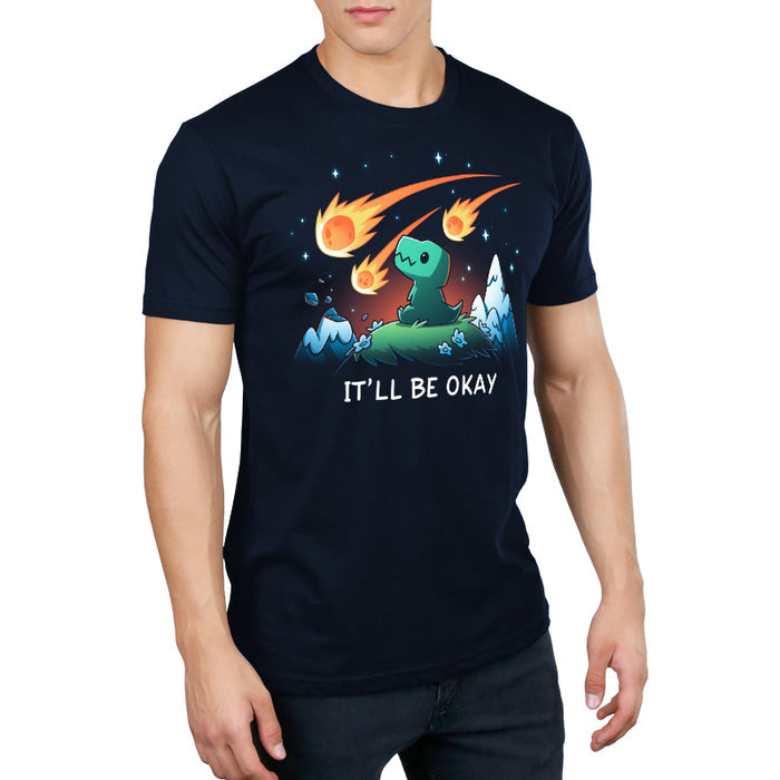Premium Cotton T-shirt_TeeTurtle navy blue It'll Be Okay featuring a green dinosaur who sits on a grassy hill with comet-like objects falling from the sky around them with the words "IT'LL BE OKAY" below them.