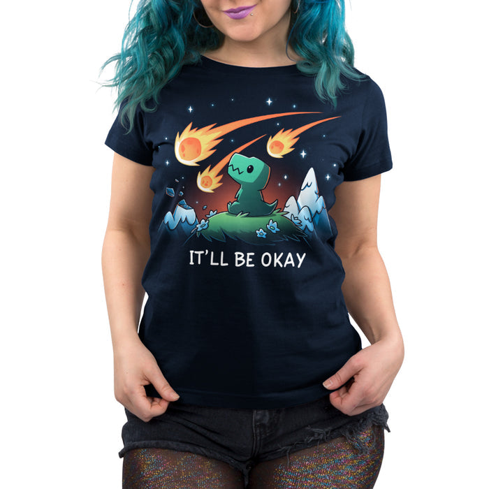 Premium Cotton T-shirt_TeeTurtle navy blue It'll Be Okay featuring a green dinosaur who sits on a grassy hill with comet-like objects falling from the sky around them with the words "IT'LL BE OKAY" below them.