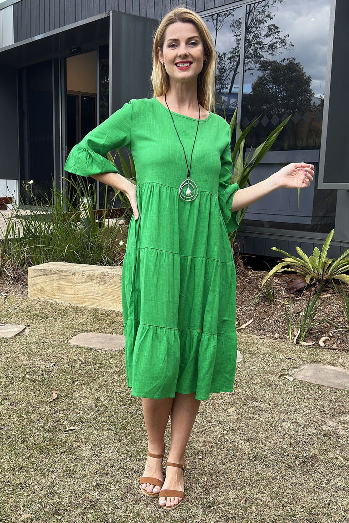 Jade green Hourglass shift tunic dress hanging on a wooden hanger, showcasing its simple, elegant design and smooth fabric.