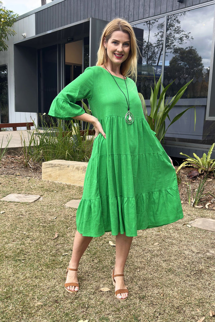 Jade green Hourglass shift tunic dress hanging on a wooden hanger, showcasing its simple, elegant design and soft fabric.