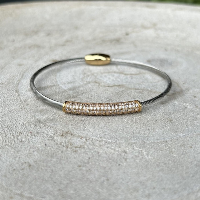This mixed metal bracelet seamlessly blends gold and silver for a modern, versatile aesthetic. The striking cubic zirconia bar adds a touch of sparkle and sophistication to any wrist. The secure magnetic closure ensures effortless wear throughout your day, making it perfect for both casual and dressed-up occasions. A timeless piece that complements any style.

Note: Silver N' Accessories jewelry is brass and stainless steel with rhodium and 18 KT gold plated. It's water resistant and anti tarnish, but it's