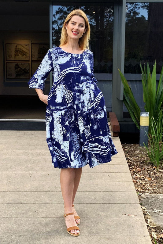 Navy and white abstract patterned tunic dress by Hourglass, featuring a loose fit and stylish design, displayed on a hanger.