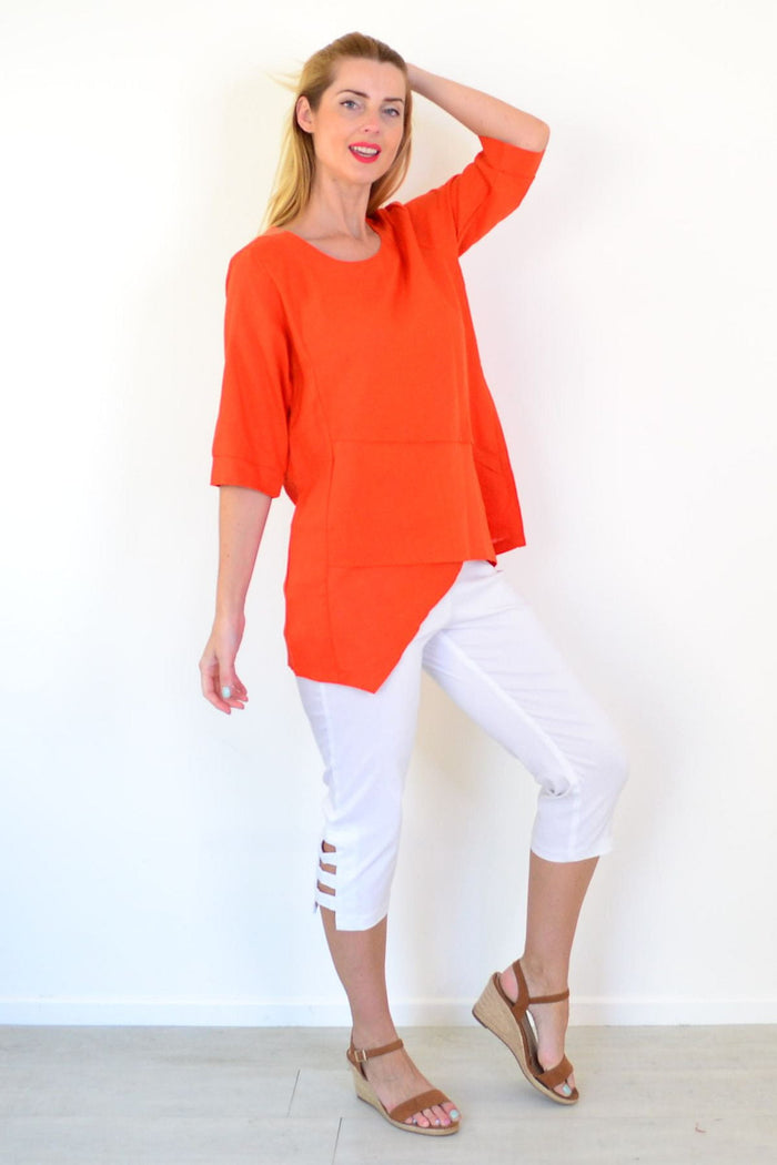 Orange layered linen blend tunic top by Ruby Rain with flowing fabric and layered design, displayed on a hanger.
