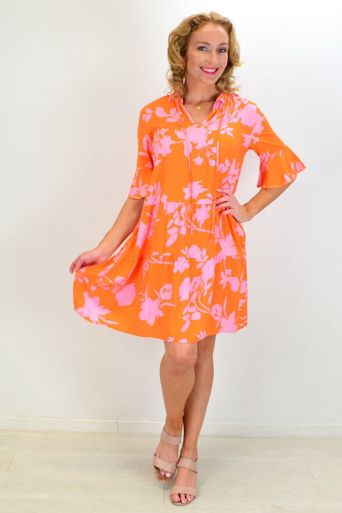 Peony orange maple leaf tiered dress tunic displayed on a hanger, showcasing its layered design and vibrant fall-inspired colors.