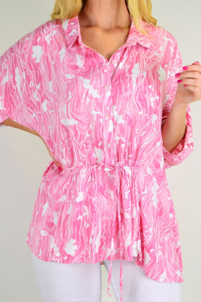 Pink River Relaxed Fit Tunic Blouse from Hourglass, featuring a flowy design and casual style, shown on a hanger.