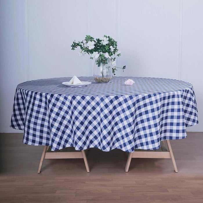 Navy blue checkered round tablecloth on a wooden table with flowers