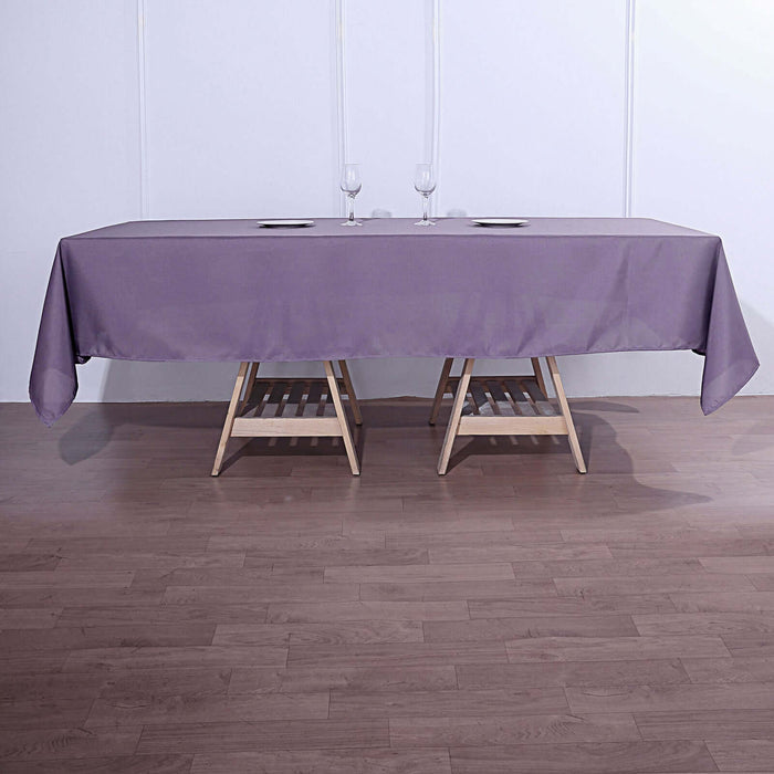 Purple tablecloth draped over a wooden table with glasses on top.