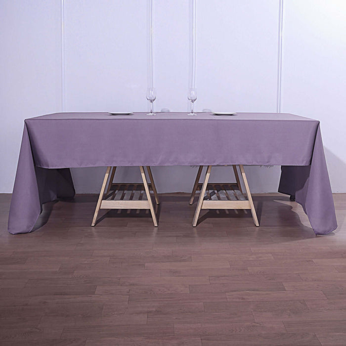 Purple tablecloth draped over a wooden table with glasses on top.