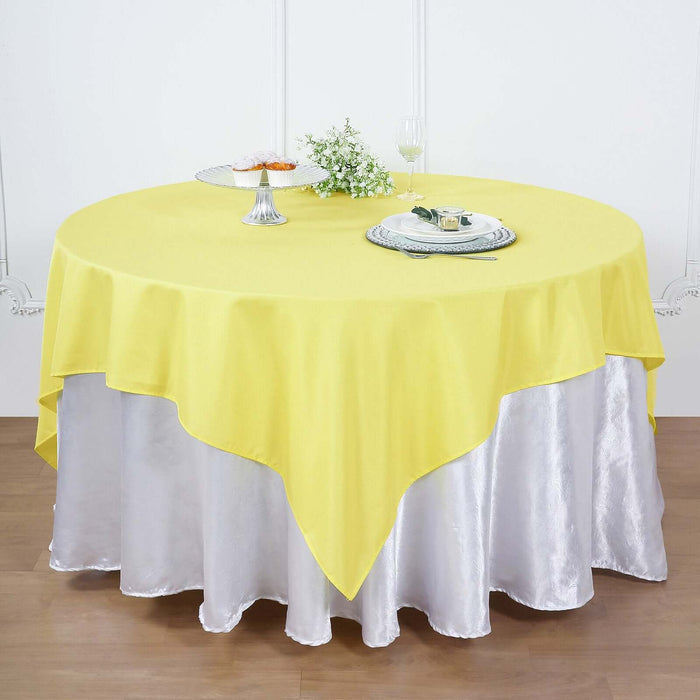 Yellow tablecloth draped over a silver table for elegant dining decor.