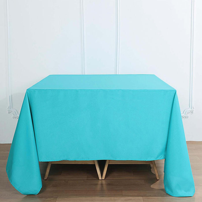 Turquoise tablecloth draped over a wooden table.
