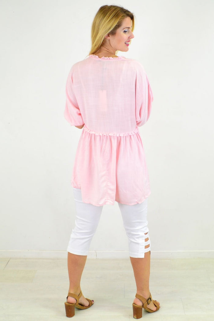 Powder pink Hourglass relaxed fit tunic blouse with long sleeves and a flowy silhouette, displayed on a hanger.