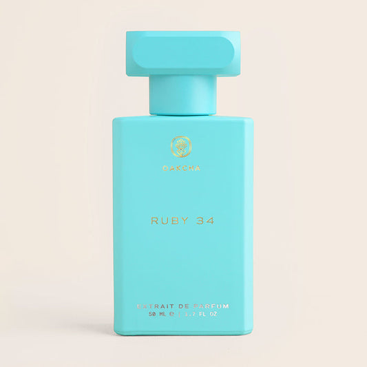 Front view of Ruby 34 50 ml perfume bottle showcasing matte turquoise bottle with gold logo on pale beige background