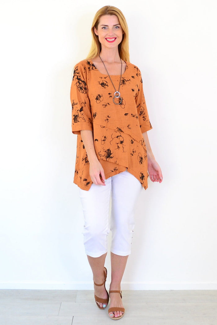 Rust-colored layered linen blend tunic top by Ruby Rain, shown hanging with its relaxed fit and textured fabric.