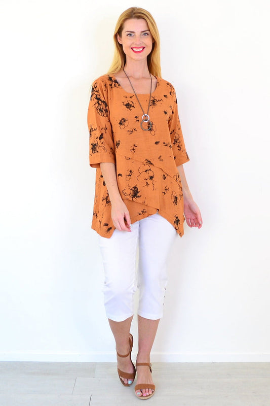 Rust-colored layered linen blend tunic top by Ruby Rain, shown hanging with its relaxed fit and textured fabric.