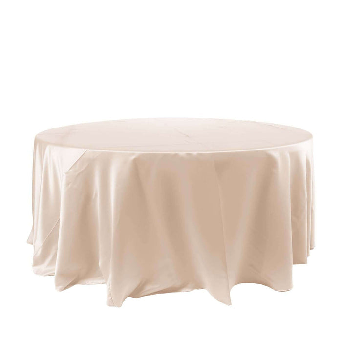 Round beige tablecloth on a plain backdrop.