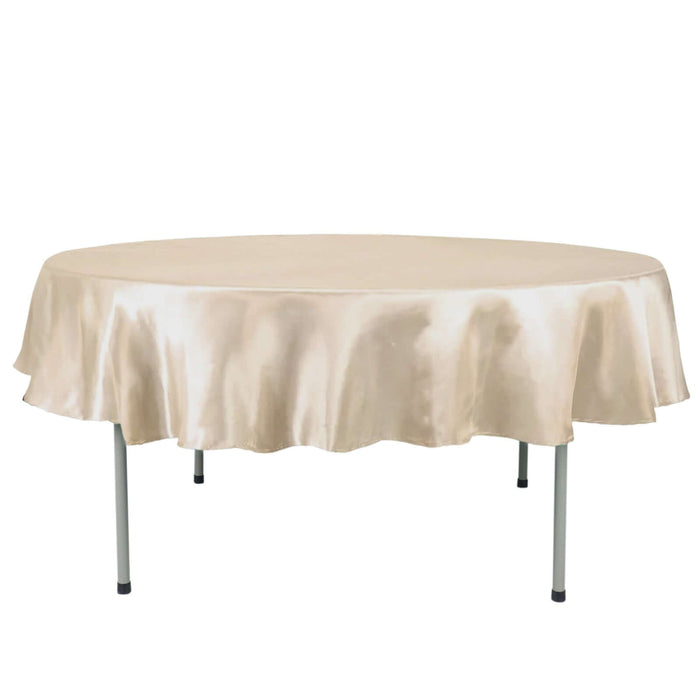 Round satin tablecloth in beige, draped elegantly over a folding table.
