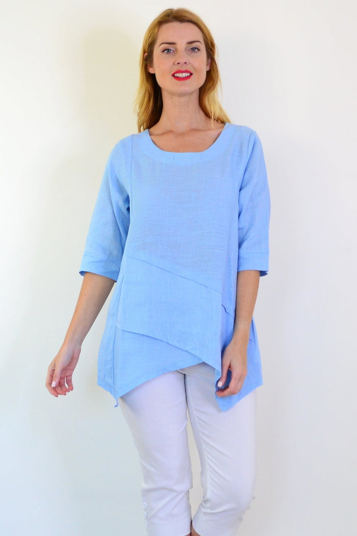 Sky blue layered linen blend tunic top by Ruby Rain, featuring flowing fabric and a relaxed fit, shown on a model.