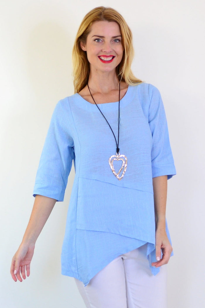 Sky blue layered linen blend tunic top by Ruby Rain, showing the flowy fabric and layered design on a mannequin.