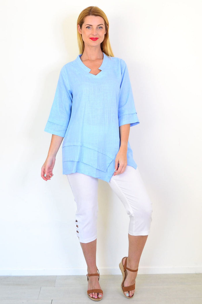 Sky blue linen blend tunic top by Ruby Rain, featuring a relaxed fit and flowing design, displayed on a hanger.