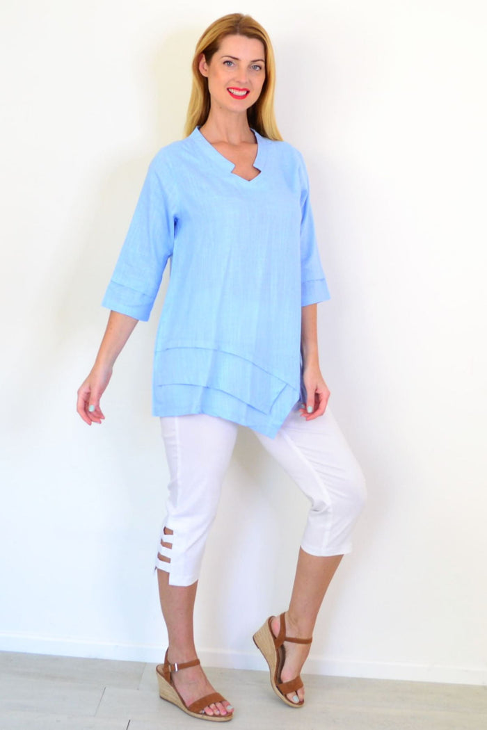 Sky blue linen blend tunic top from Ruby Rain, featuring a relaxed fit and lightweight fabric, displayed on a hanger.