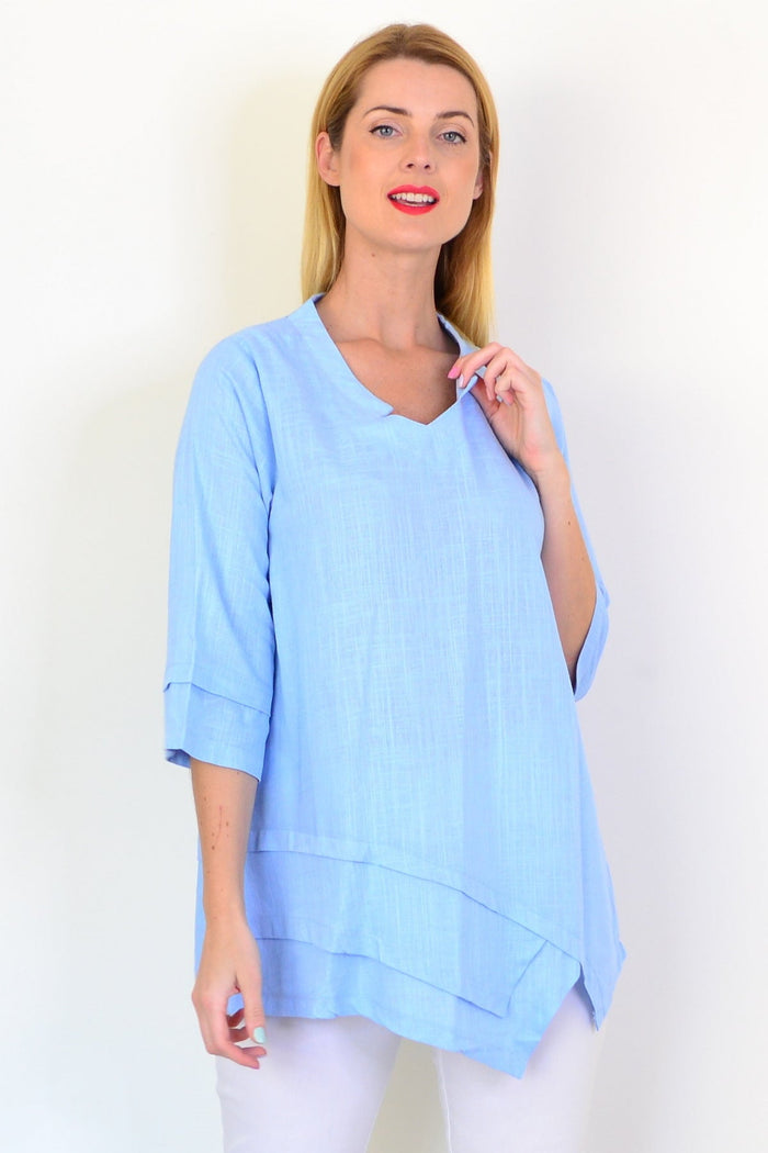 Sky blue linen blend tunic top by Ruby Rain, showing a relaxed fit with long sleeves and a round neckline on a mannequin.
