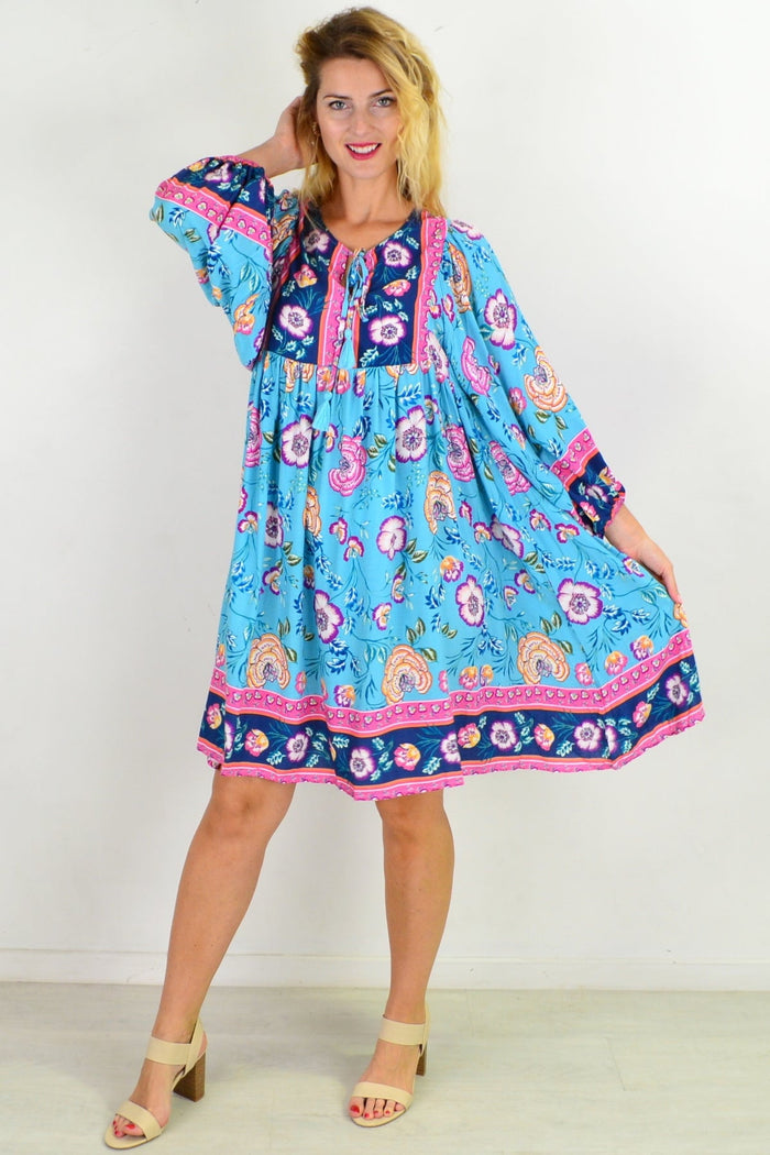Soft blue Moroccan style boho tunic dress by I Love Tunics, featuring flowing fabric and intricate patterns, displayed on a hanger.