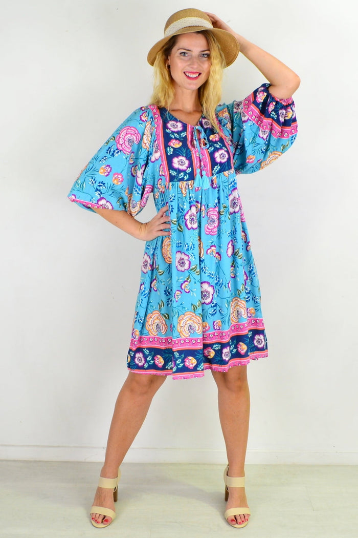 Soft blue Moroccan-style boho tunic dress by I Love Tunics, featuring flowing fabric and intricate patterns, displayed on a hanger.