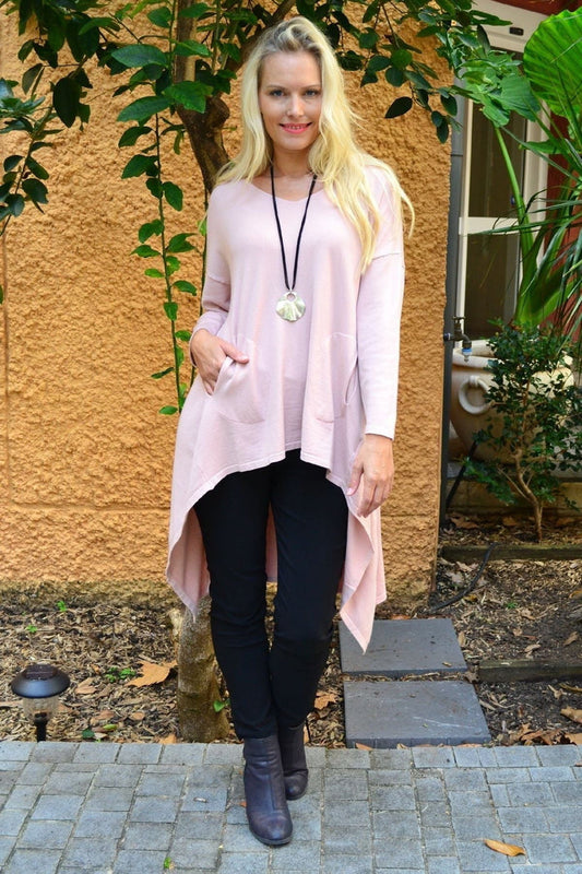 Soft pink Heidi hi-low tunic jumper by Cali&Co, featuring a flowy silhouette and casual style, displayed on a hanger.
