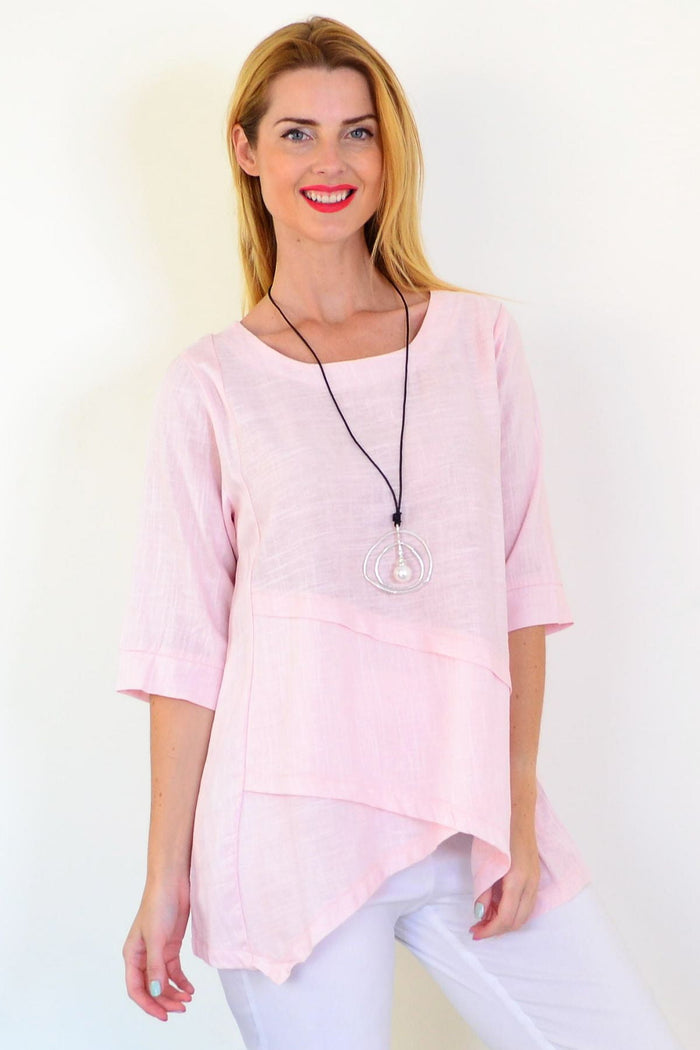 Soft pink linen blend tunic top by Ruby Rain, displayed on a hanger with a relaxed fit and lightweight fabric.