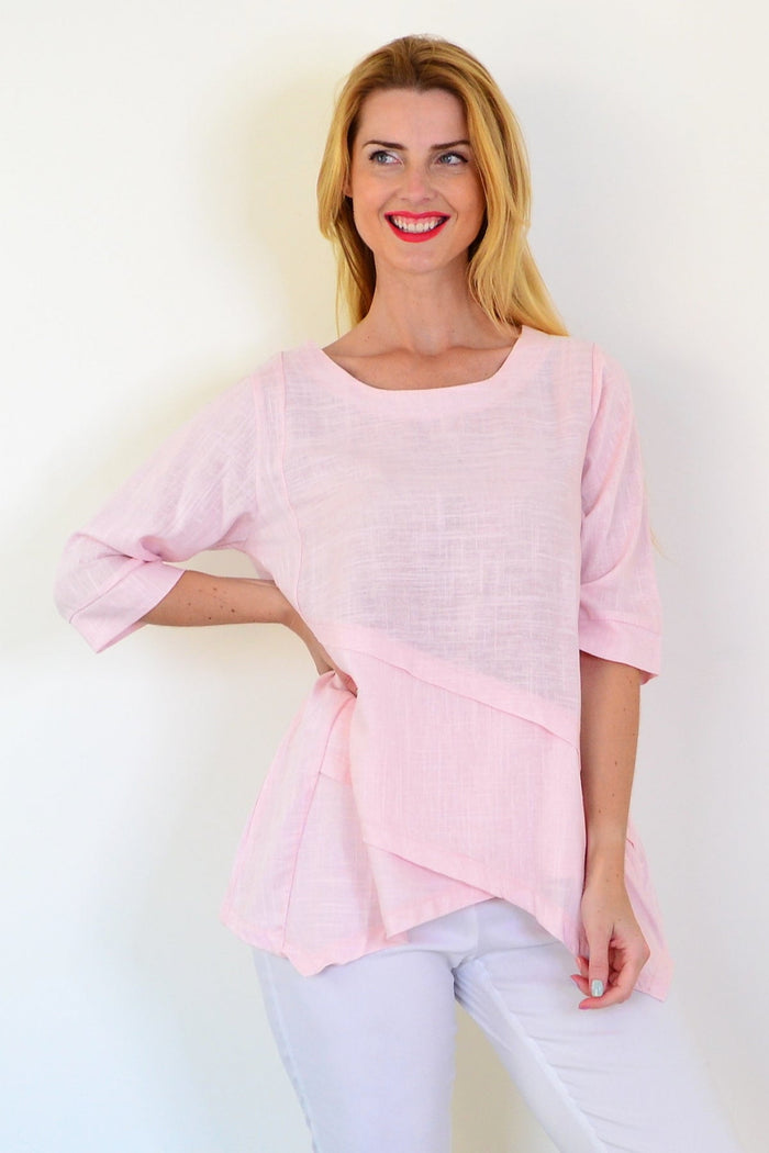 Soft pink linen blend tunic top by Ruby Rain with a relaxed fit and flowing fabric, displayed on a hanger.
